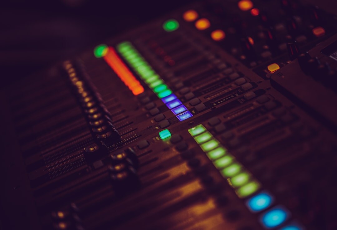 Audio mixing console with glowing sliders and meters